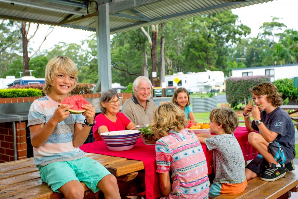 Family eating together in the camp kitchen at Reflections Holiday Parks Coffs Harbour
