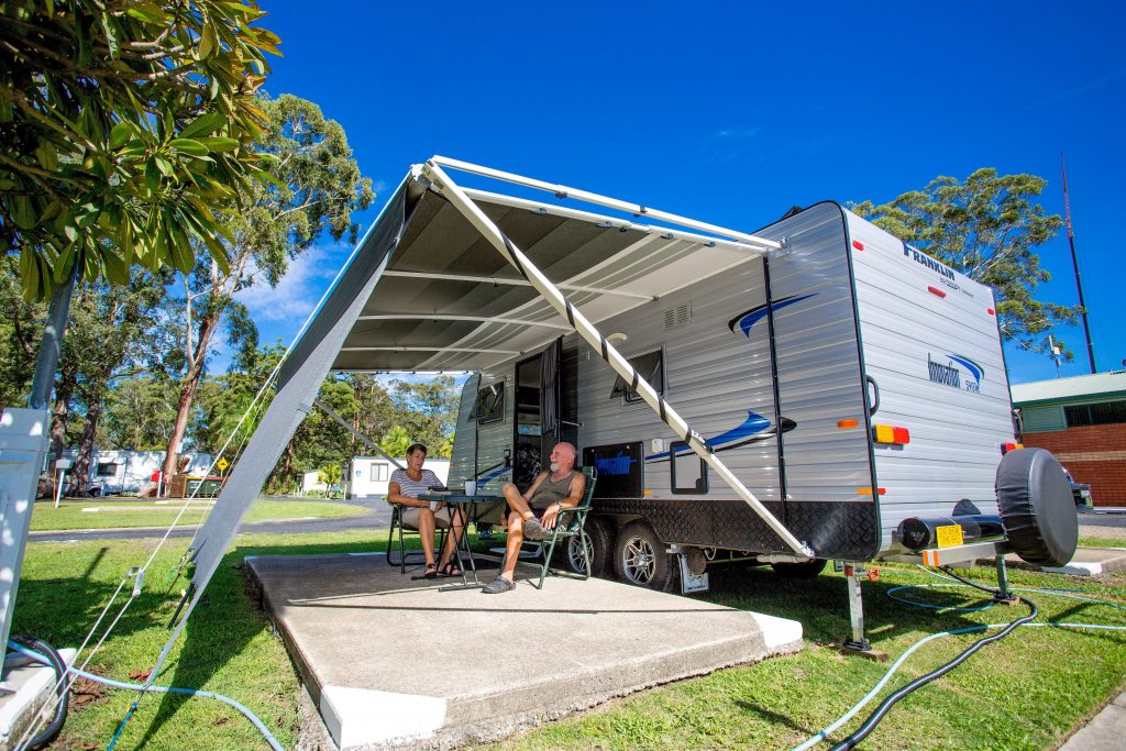 Couple sitting outside caravan at Reflections Holiday Parks Coffs Harbour